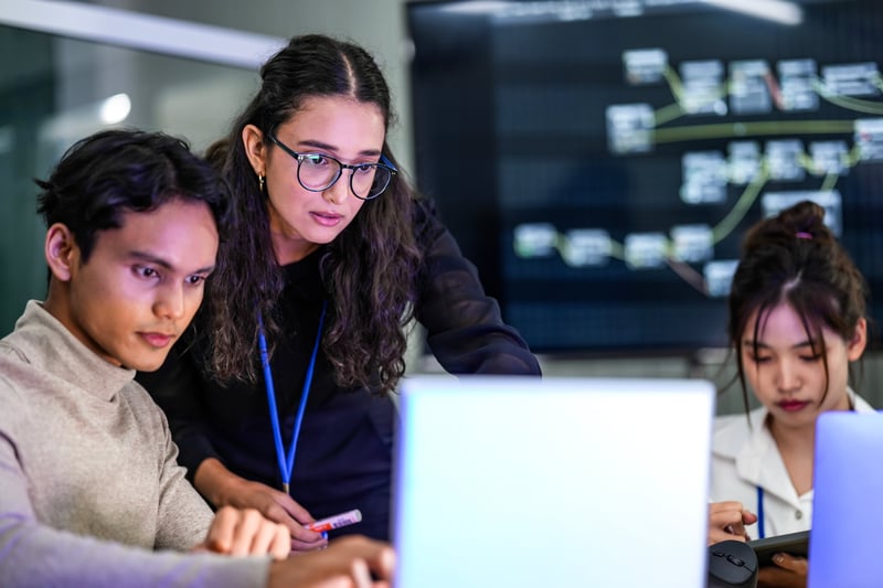 multiracial business professionals looking at laptop screen