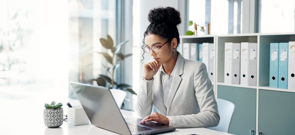 woman at desk looking at computer
