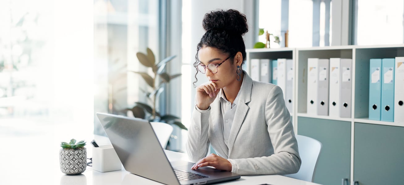woman at desk looking at computer