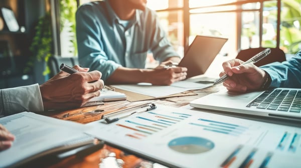 hands of business professionals working at table with paper reports