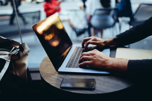 male hands typing on laptop keyboard