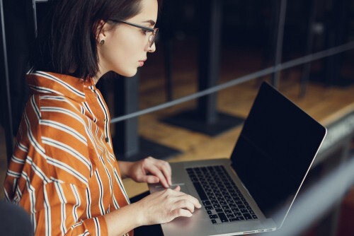 side view of woman working on a laptop