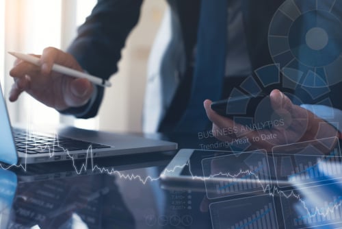 image of hands with devices showing digitized business graphs