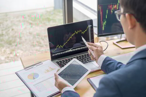businessman looking at screens with charts and graphs