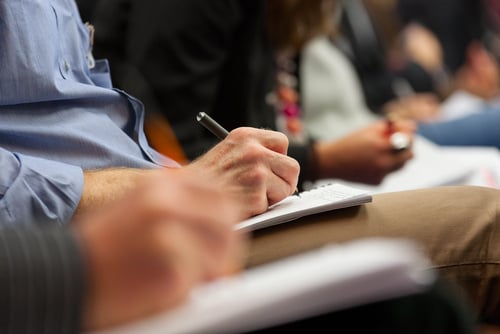 image of hands wrting on paper taking notes