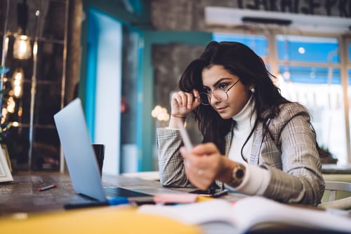 young business woman with glasses looking at laptop screen