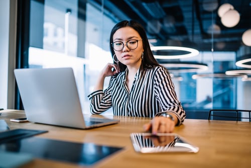 woman working at laptop and device screen