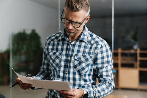 man in dealership studying at paperwork
