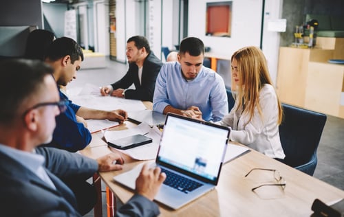 team of business employees working around a table