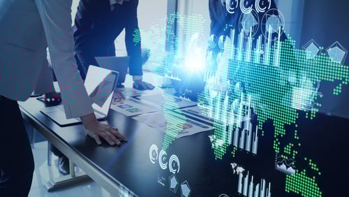 business employees looking at global map and computer screen