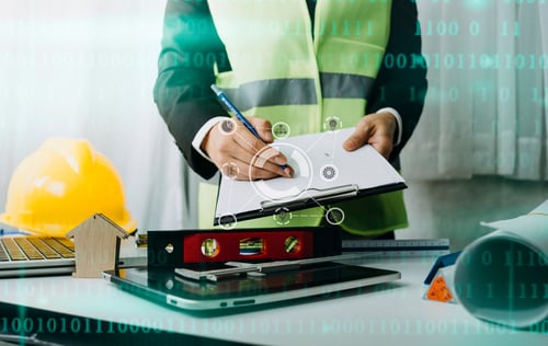 engineer with paperwork and hardhat in an office