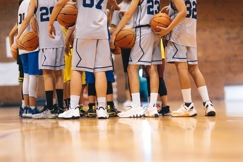 group of college basketball players in huddle