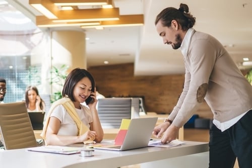 male and female professionals at work with desk and laptop