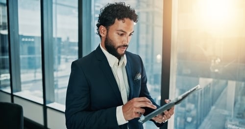 image of man in city window looking at tablet