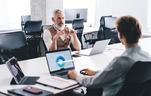 2 male business professionals meeting at a conference table 