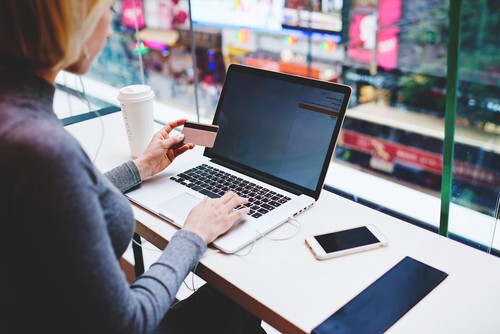 female using laptop at desk and making an electronic payment