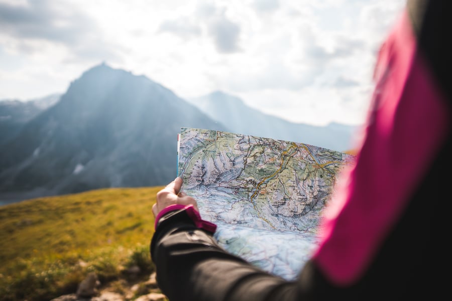 hiker on trail reading a map